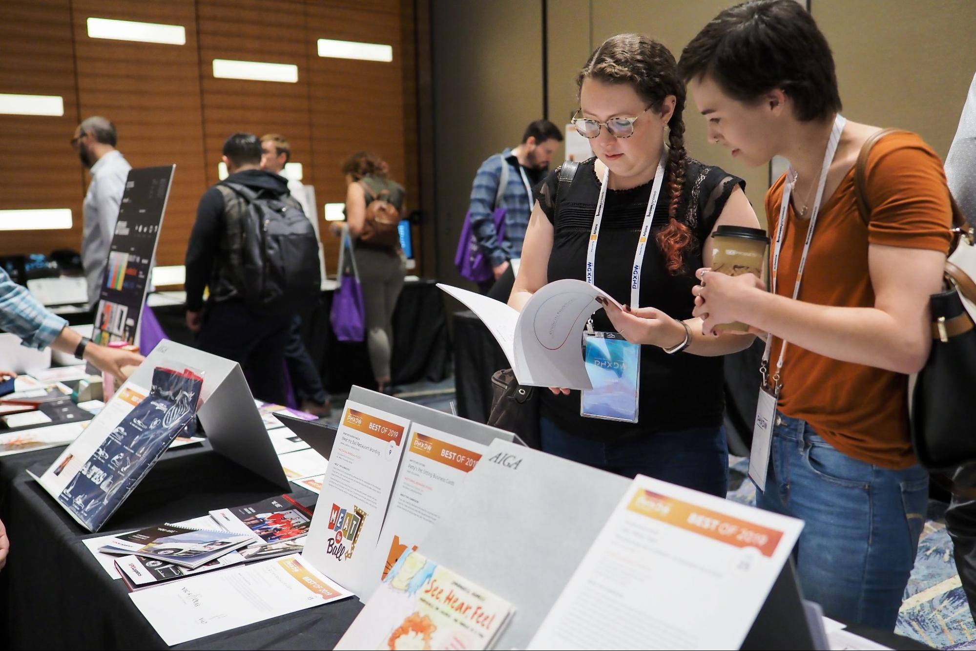 two conferences attendees looking through printed material